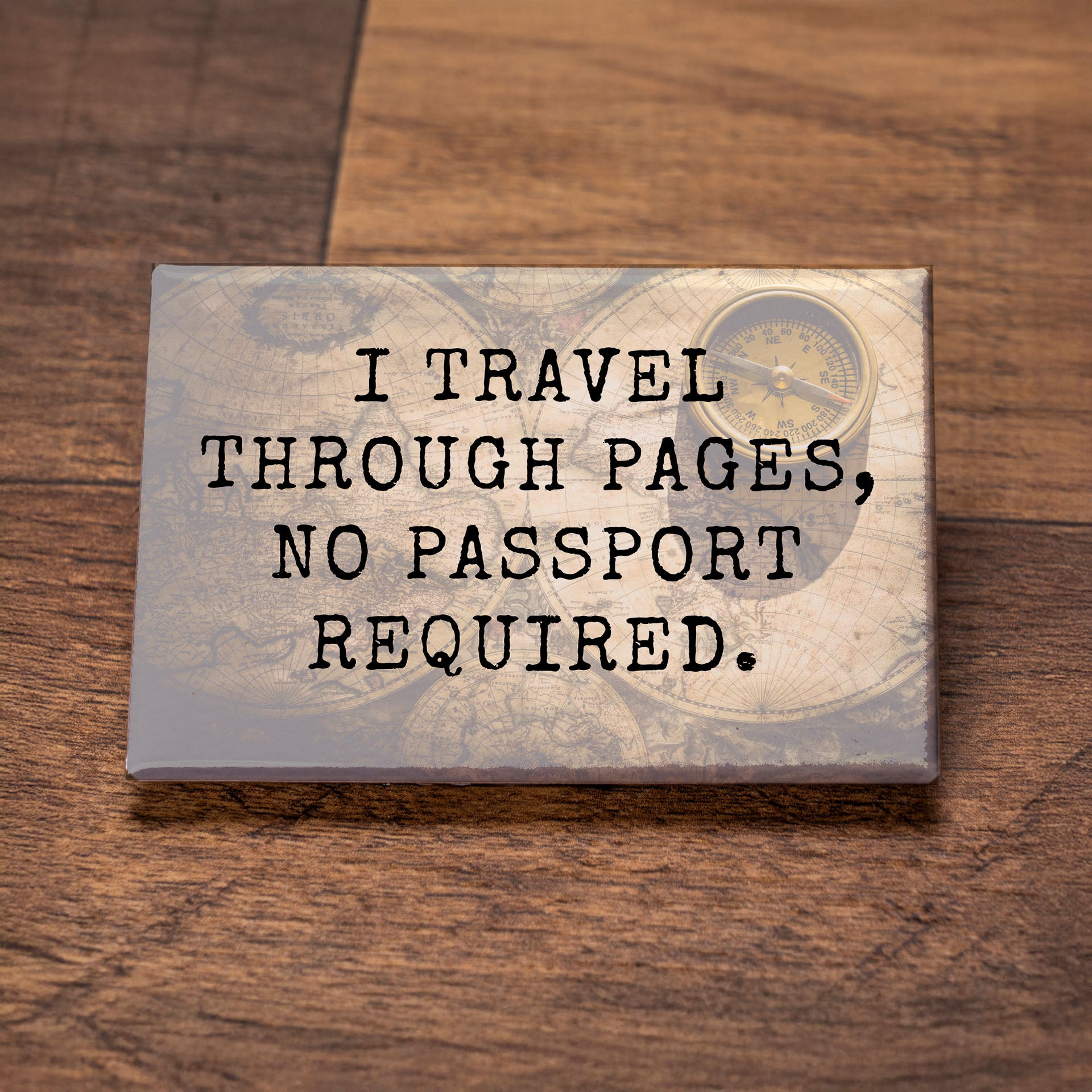 Decorative sign with text 'I travel through pages, no passport required.' on a wooden surface.